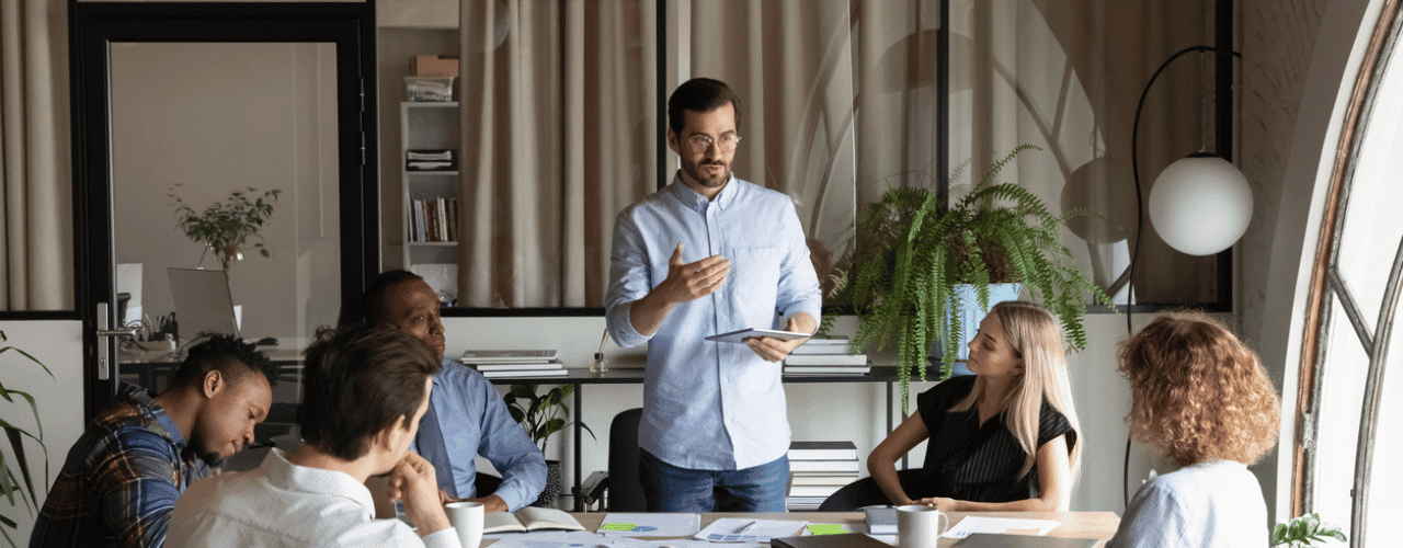 Sales director leading a team workshop with approval matrices and coaching grid